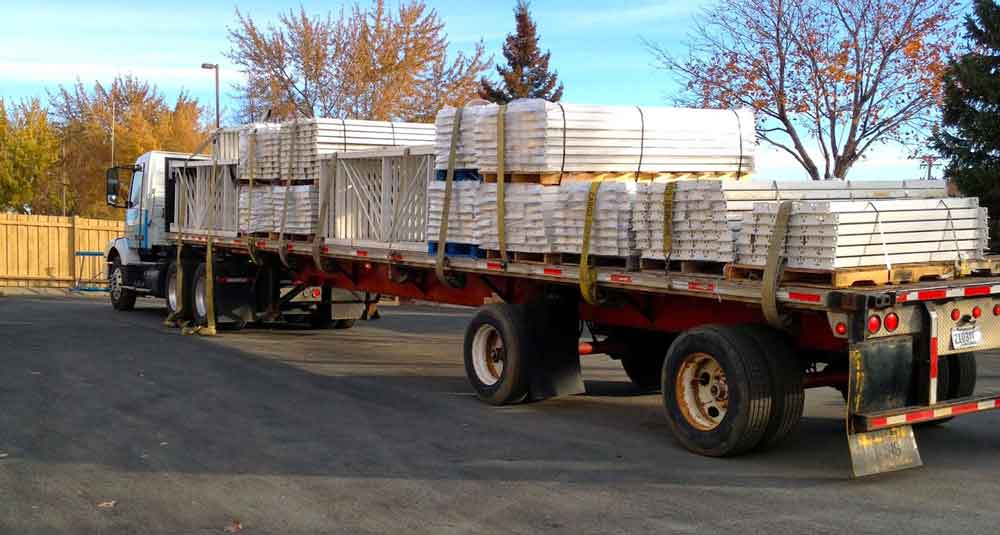 Used pallet racking is loaded high on the back of a flatbed ready to ship
