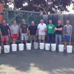 AK Employees stand in a line with ice buckets in front of them