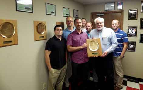 AK Employees Smile and stand with Ridg-U-Rak's Baker's Dozen award