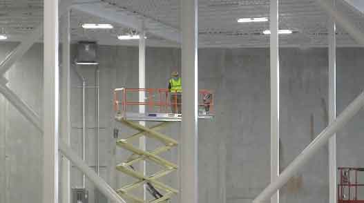 Pallet racking installer standing on an aerial work platform