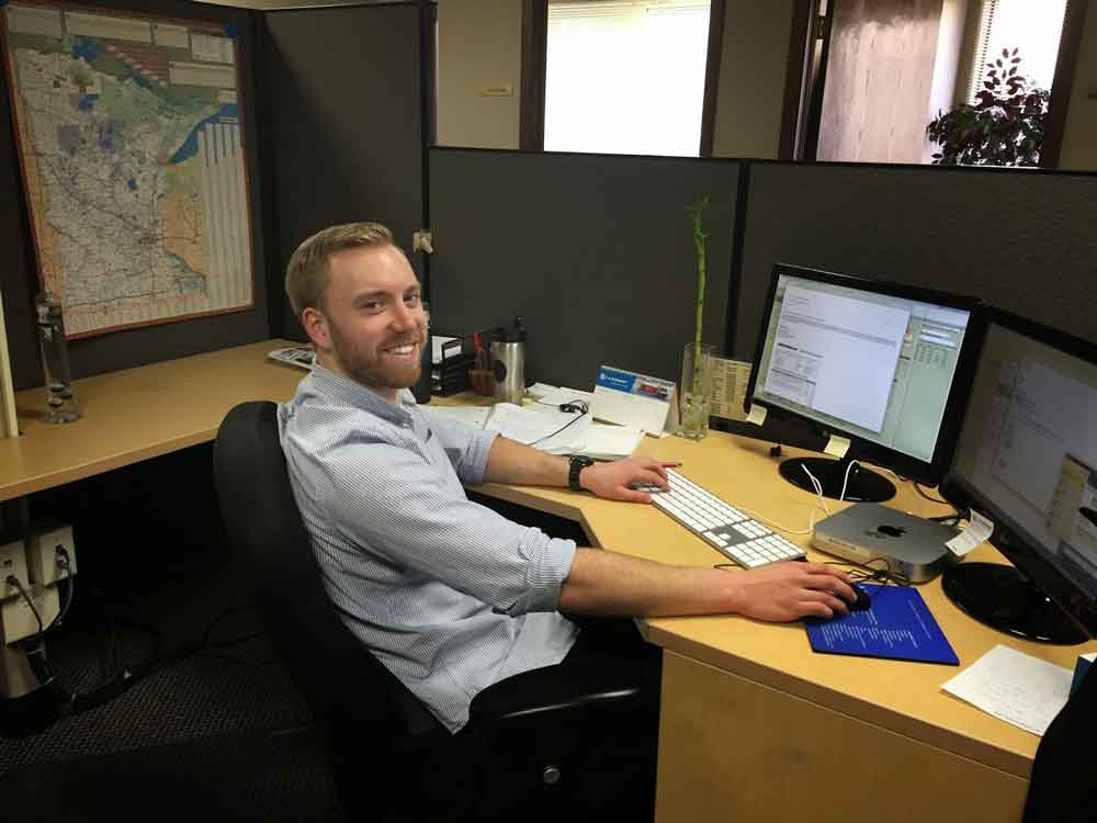 AKMHS Employee Dave Sewich smiles and works at his desk