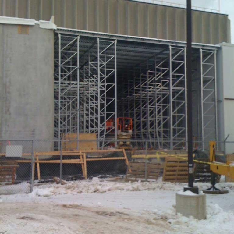 A snowy exterior shot shows a building that is supported by racking