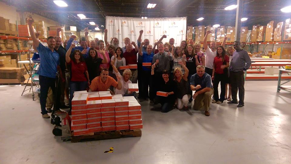 AK Employees in a warehouse smile as they finished their volunteer opportunity with the nonoproft Matter