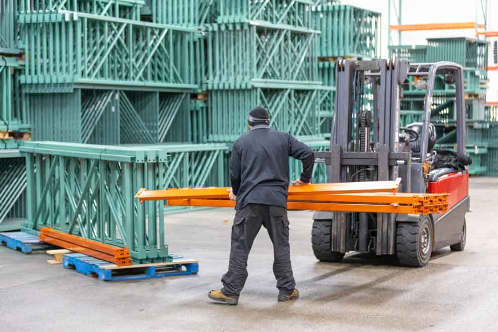 Warehouse team member preparing a pallet rack shipment for delivery
