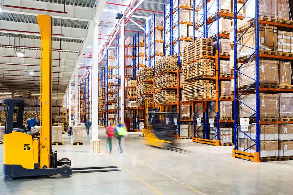 A bustling distribution warehouse filled with selective pallet racking at full capacity