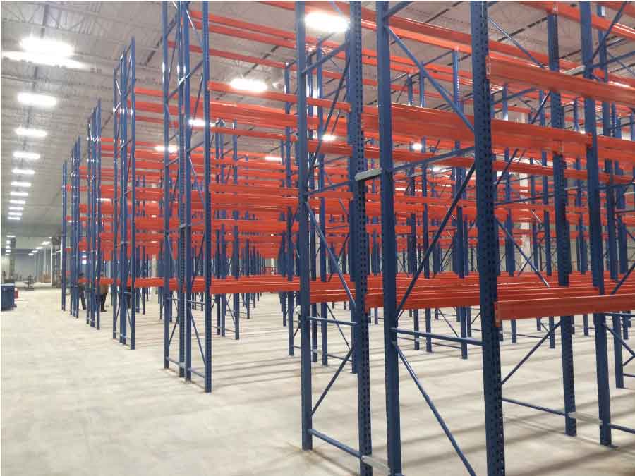 Rows of blue and orange pallet racking sit empty as they are installed in the miners’ grocery store warehouse